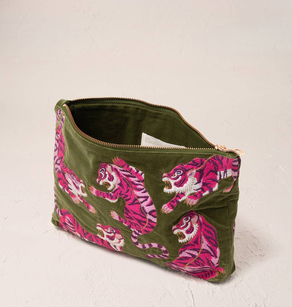 Green pouch with pink tiger embroidery on a light gray background