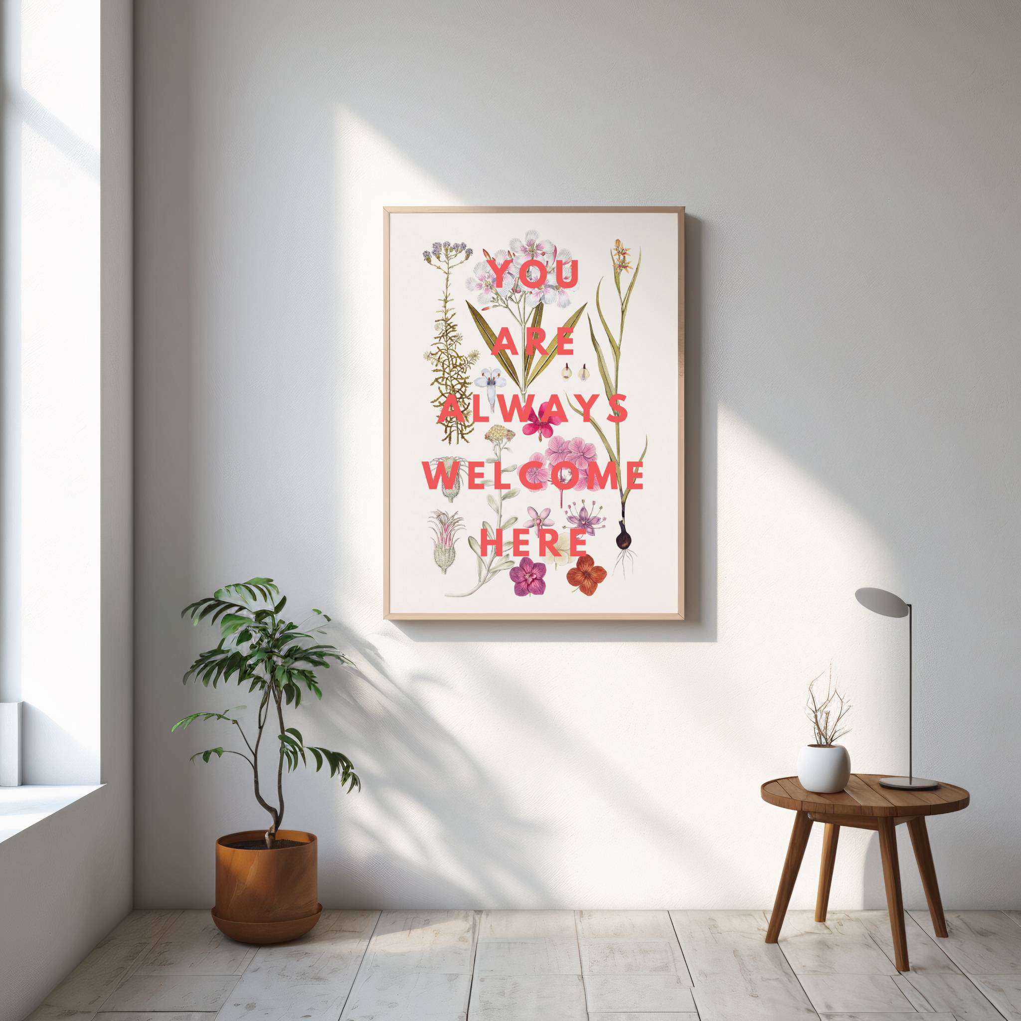 Framed artwork with motivational quote in a bright room with plants and a small table.