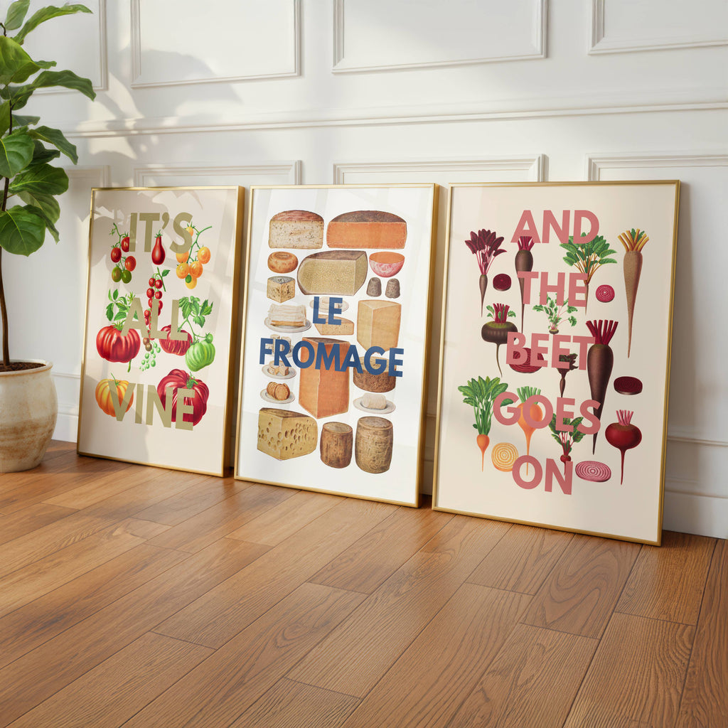 Three framed foodie prints on a wooden floor with decorative elements.