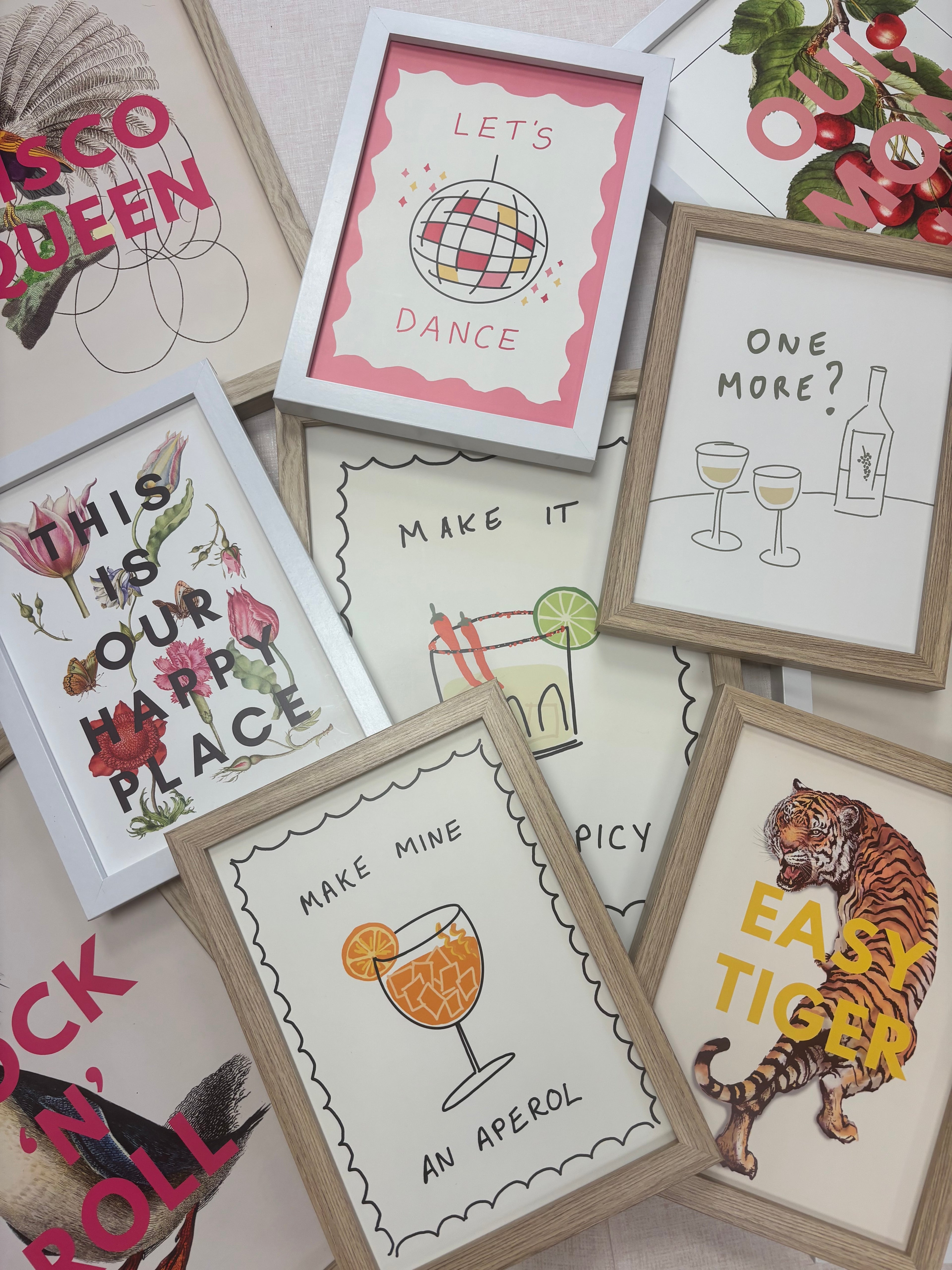 Collection of framed prints with various designs and text on a surface.