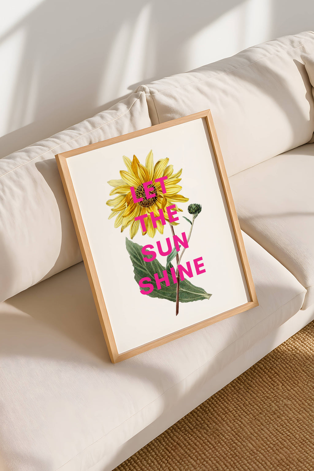 Framed artwork with sunflower and 'Let the Sun Shine' text on a white surface